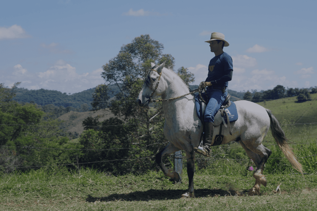 Fabiano montando em um cavalo branco com a marca do Criatório Aperana